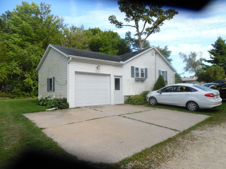 9838 East Flagg Road Rochelle, IL 61068 - Photo 5 of 12 a white house that has a tree in front of it