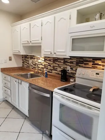 a kitchen with granite countertop a stove sink and cabinets