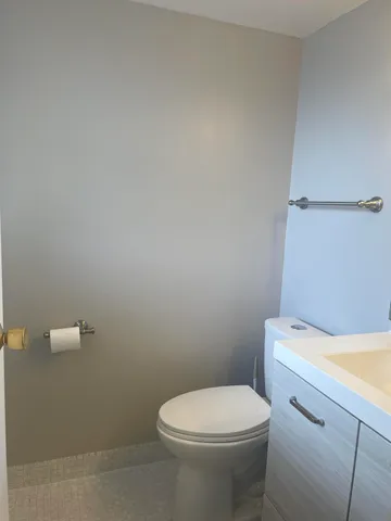 a white toilet sitting next to a white wall