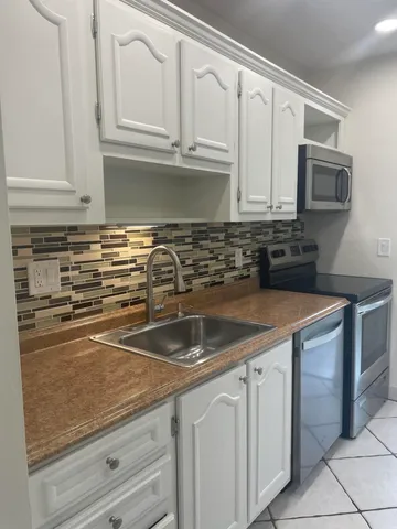 a kitchen with granite countertop a sink and cabinets