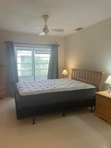 a bed sitting in a room next to a lamp