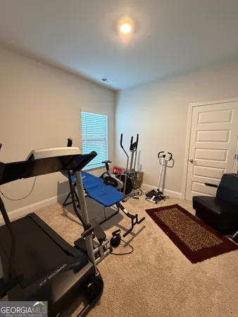 a room with gym equipment and wooden floor