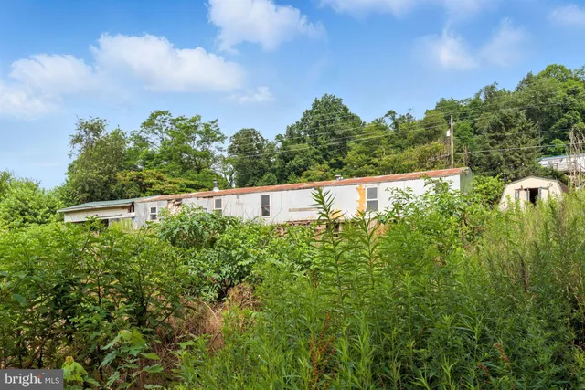 a view of a hallway with furniture and refrigerator