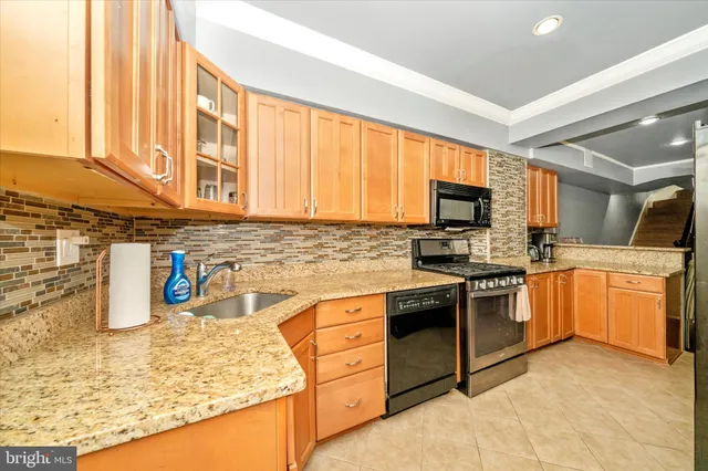 a kitchen with stainless steel appliances granite countertop a stove sink and cabinets