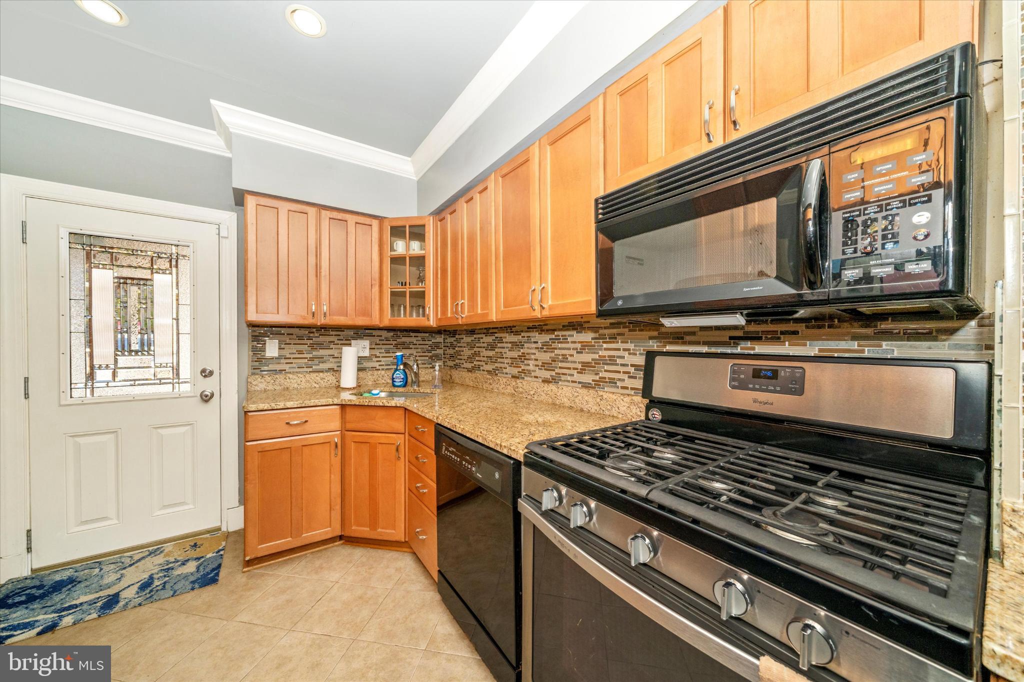 1221 William Street Baltimore, MD 21230 - Photo 15 of 44 a kitchen with a stove a sink and a microwave