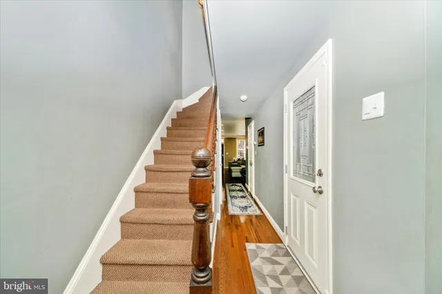 a view of a hallway with wooden floor and entryway