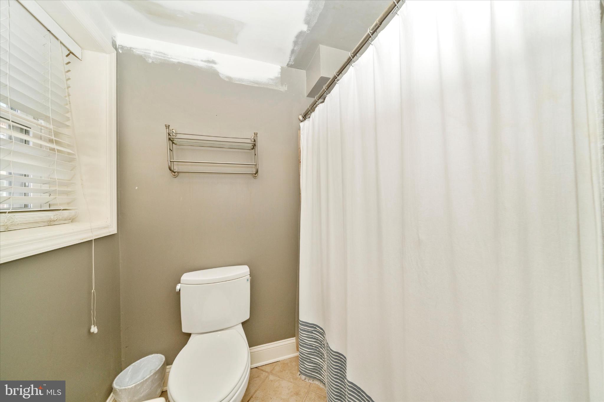 1221 William Street Baltimore, MD 21230 - Photo 25 of 44 a bathroom with a toilet and a shower curtain