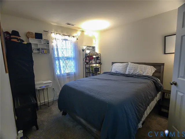 a bedroom with a bed and a large mirror