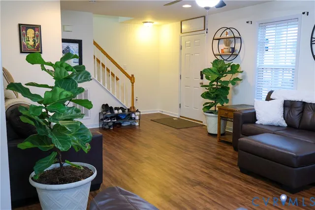 a living room with furniture potted plant and wooden floor