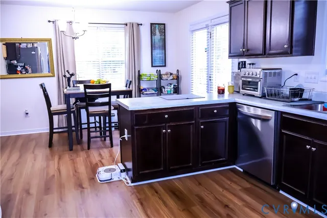 a kitchen with stainless steel appliances granite countertop wooden floors a sink and a window