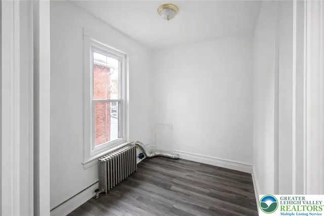 a view of a hallway with wooden floor and windows