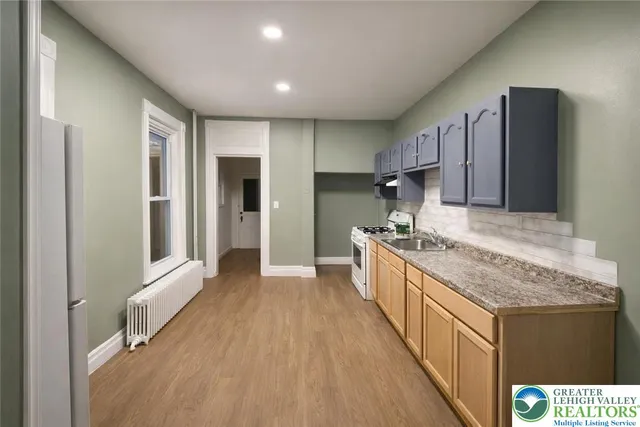 a kitchen with stainless steel appliances granite countertop a stove a sink and a refrigerator