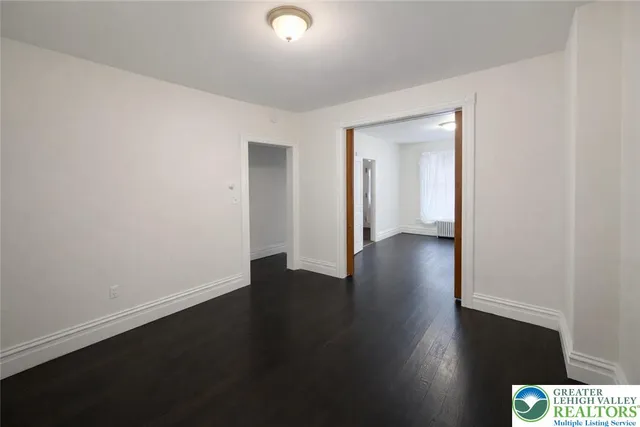 a view of an empty room with wooden floor