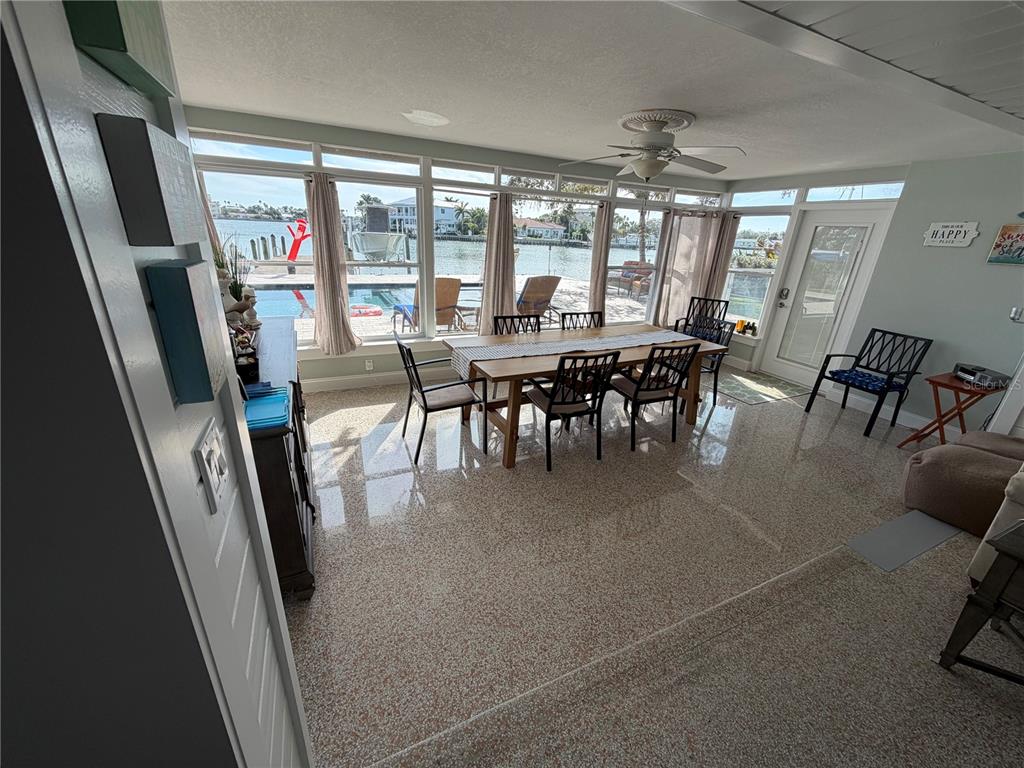 433 20th Avenue Indian Rocks Beach, FL 33785 - Photo 16 of 23 a dining room with furniture a rug a flat screen tv and a dining table