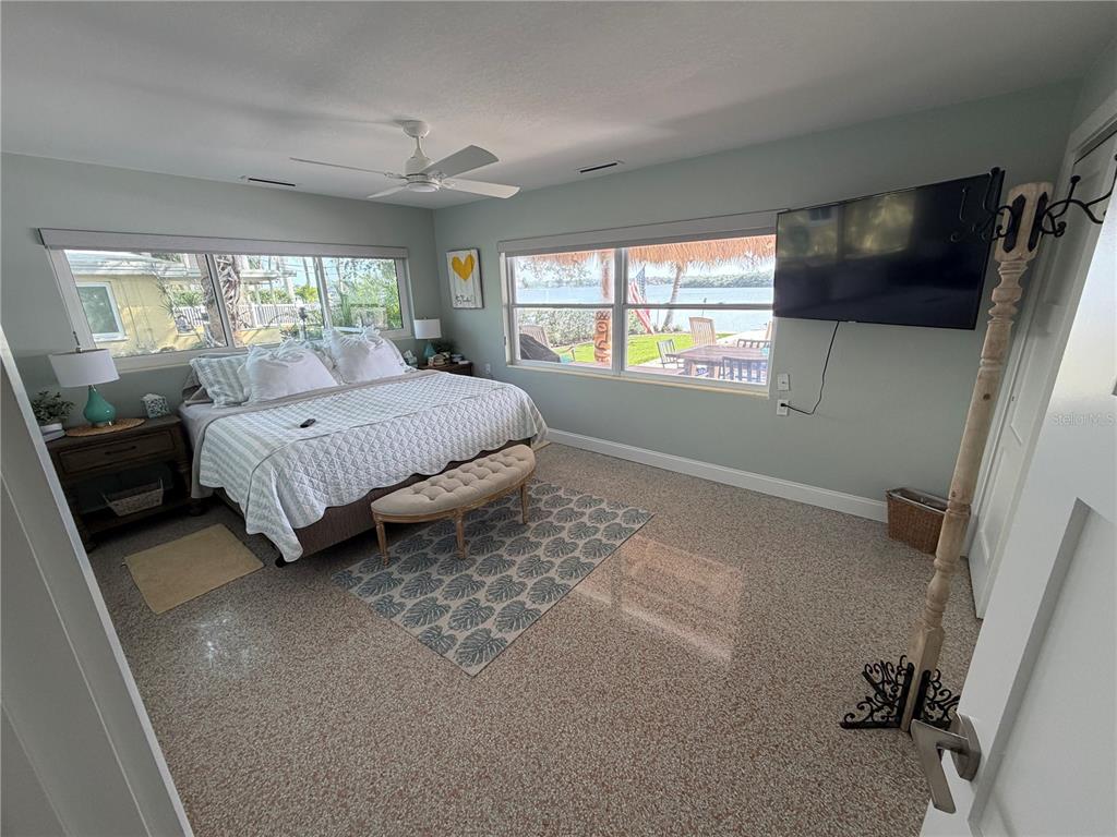 433 20th Avenue Indian Rocks Beach, FL 33785 - Photo 4 of 23 a spacious bedroom with a bed and a flat tv screen next to a window