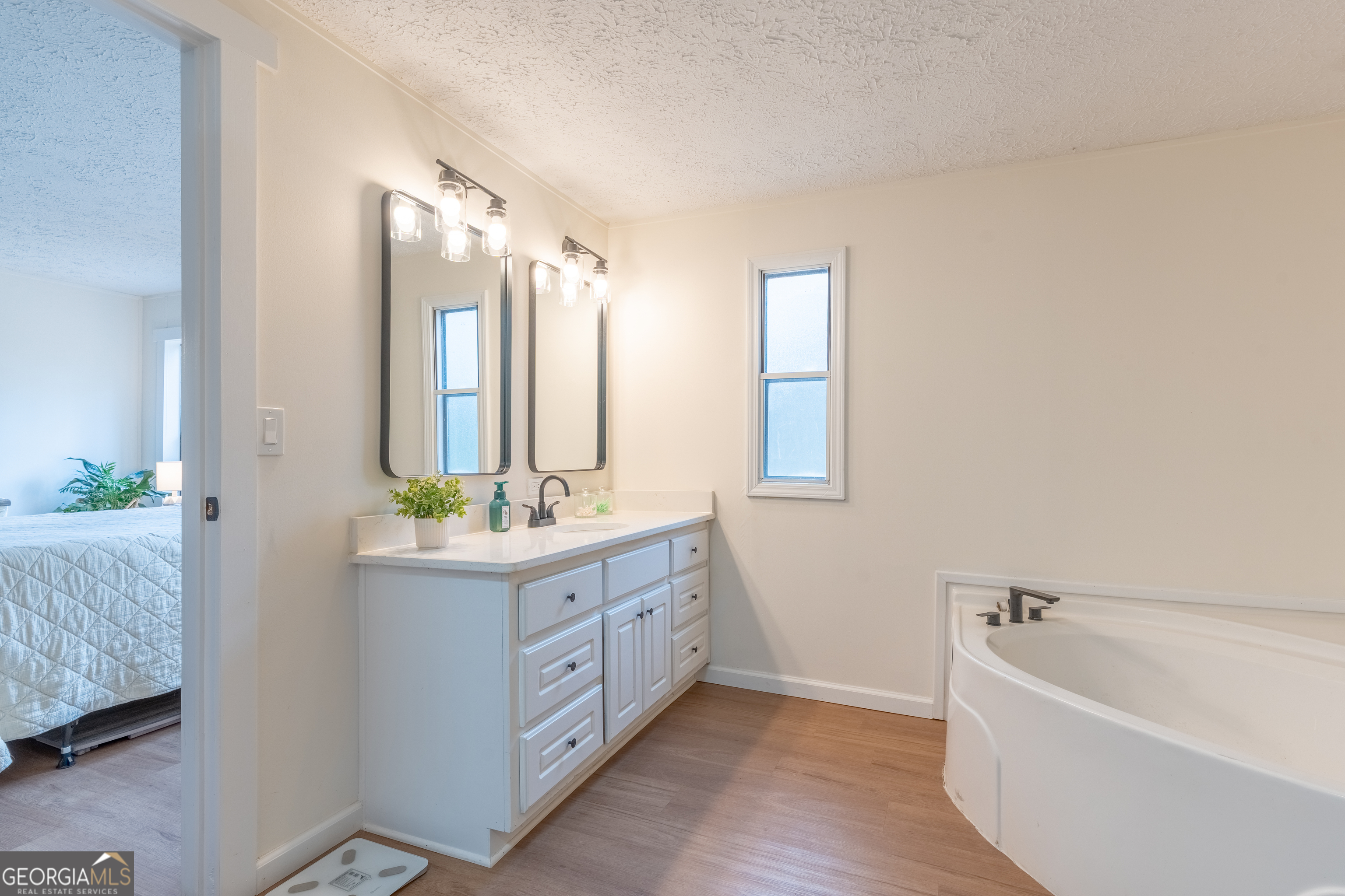 452 Aikenton Road Monticello, GA 31064 - Photo 22 of 47 a bathroom with a granite countertop sink mirror and bathtub