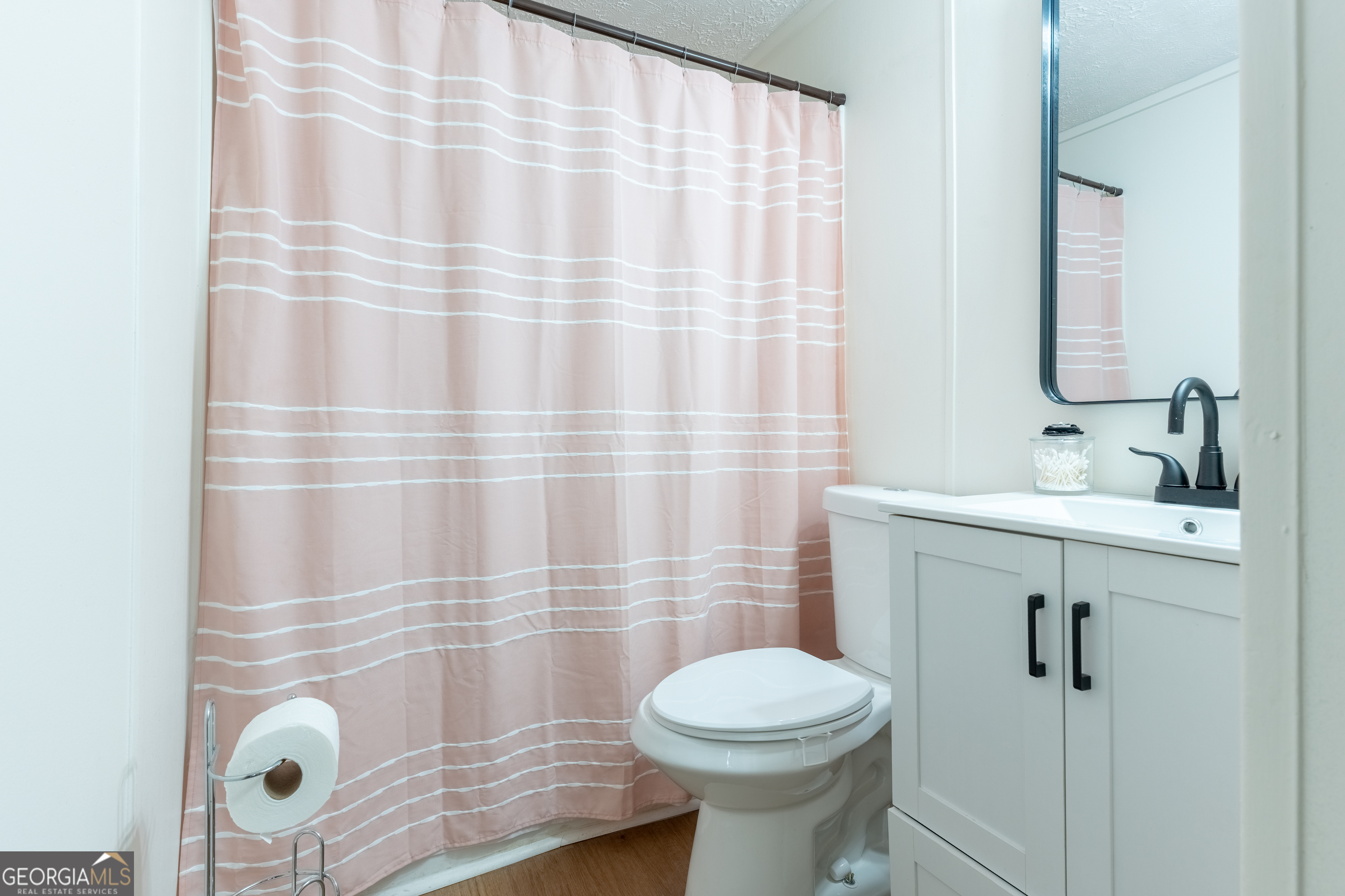 452 Aikenton Road Monticello, GA 31064 - Photo 30 of 47 a bathroom with a sink a toilet and shower curtain