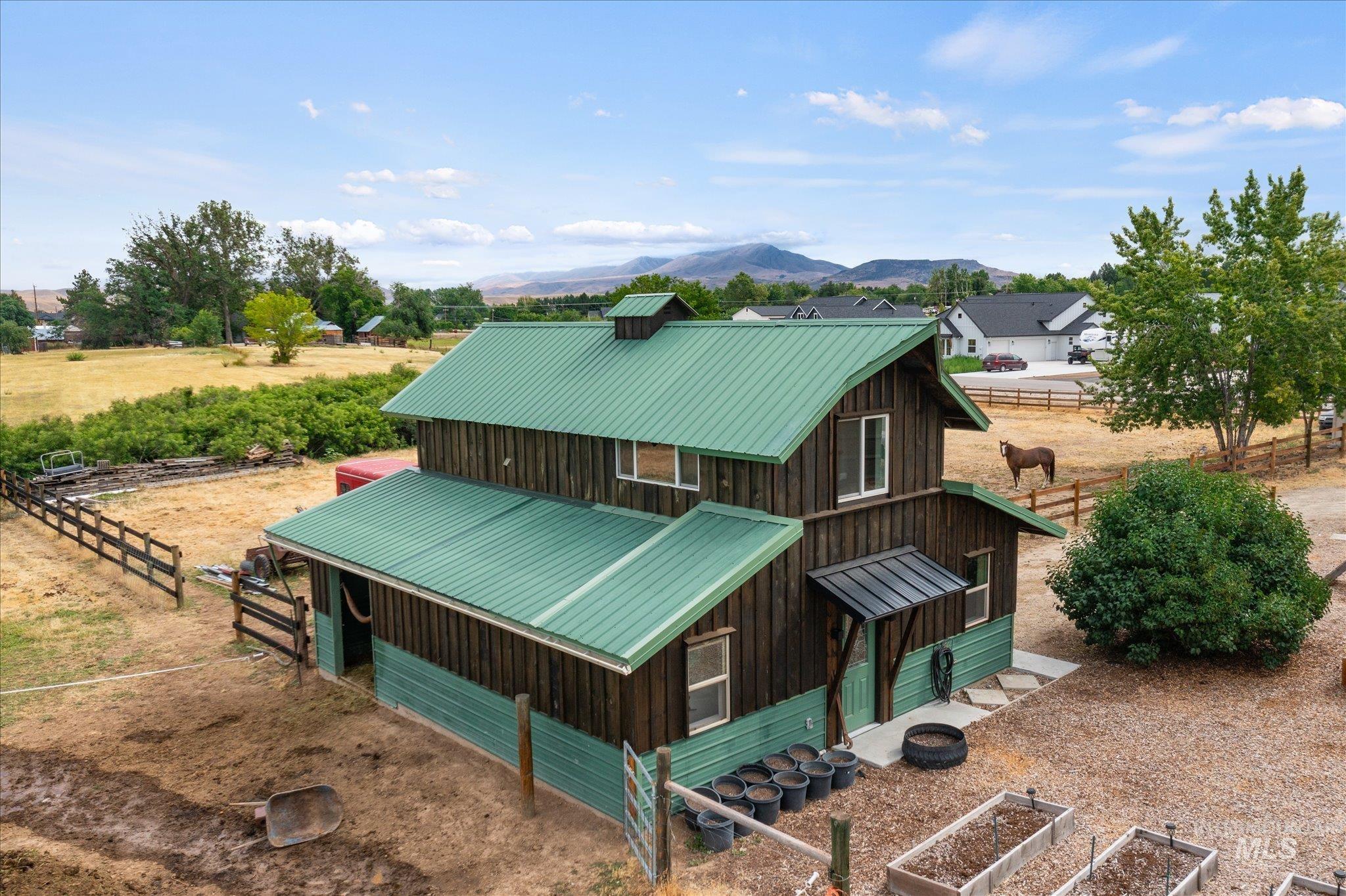 1140 Edgemont Road Emmett, ID 83617 - Photo 2 of 50 Multi-level barn structure featuring a green metal roof and dark wood-finish siding