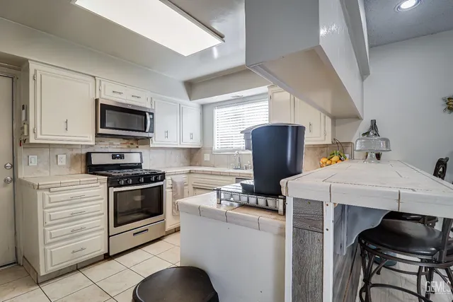 a kitchen with stainless steel appliances a stove refrigerator sink and microwave
