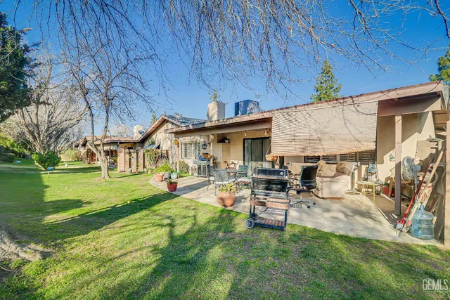 a view of a backyard with table and chairs with wooden floor and fence