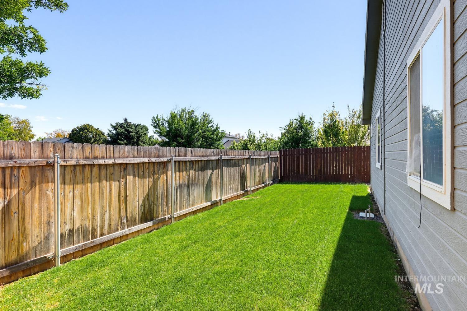 5221 Lockwood Way Caldwell, ID 83607 - Photo 26 of 27 Expansive lawn area with a wood privacy fence and horizontal siding exterior