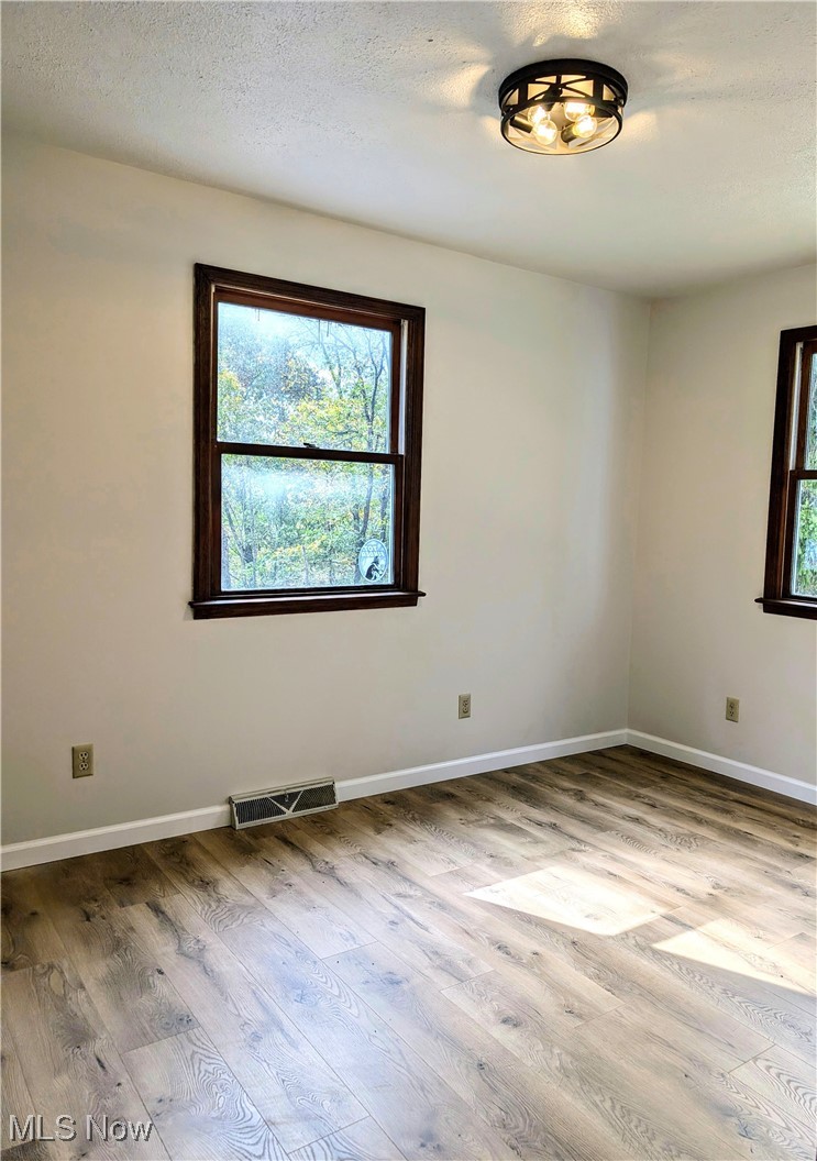 66565 Lake Ridge Road Lore City, OH 43755 - Photo 9 of 26 Main floor bedroom featuring a textured ceiling and wood-style flooring
