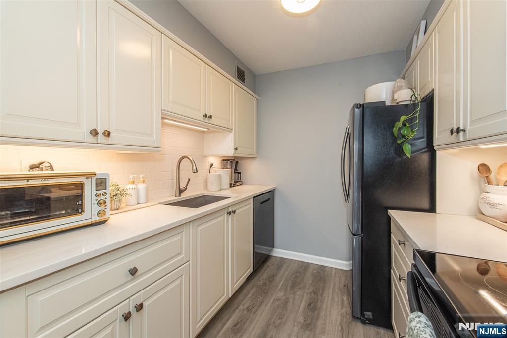 300 Main Street, Unit 211 Little Falls, NJ 07424 - Photo 12 of 30 a kitchen with a sink stainless steel appliances and cabinets