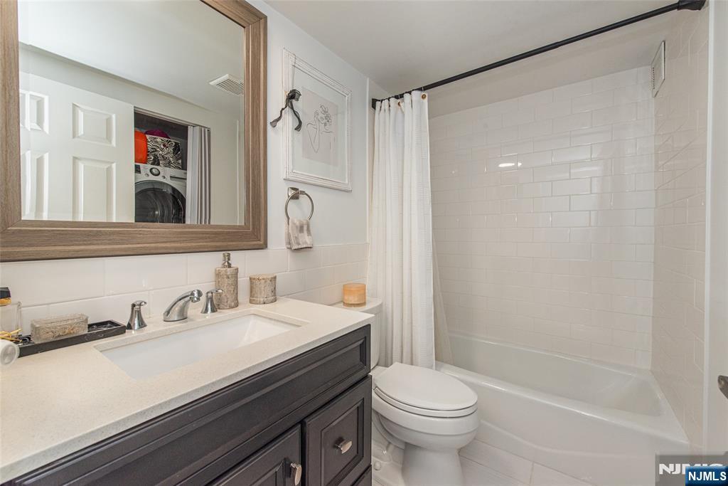 300 Main Street, Unit 211 Little Falls, NJ 07424 - Photo 14 of 30 a bathroom with a sink a toilet a shower and a mirror
