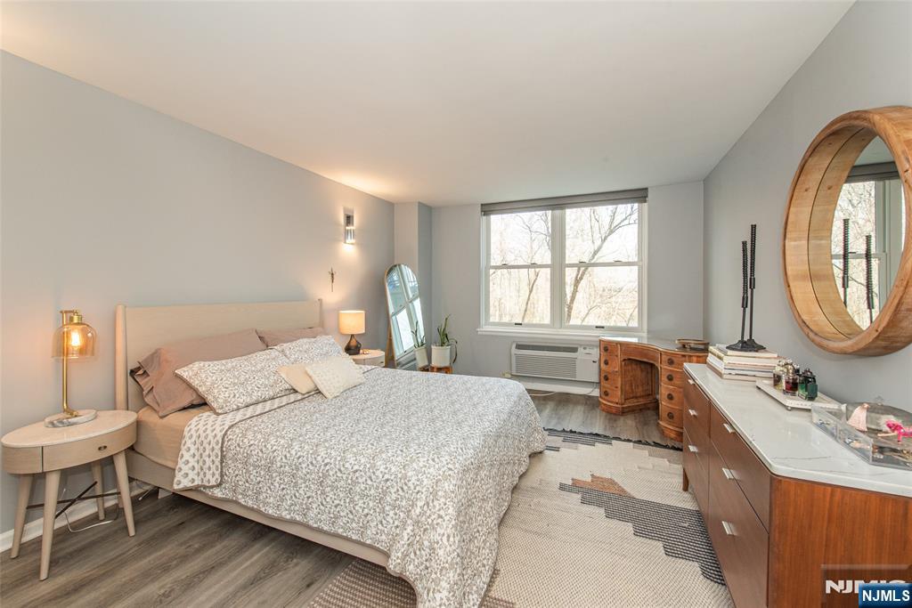 300 Main Street, Unit 211 Little Falls, NJ 07424 - Photo 17 of 30 a bedroom with a bed a mirror and a window