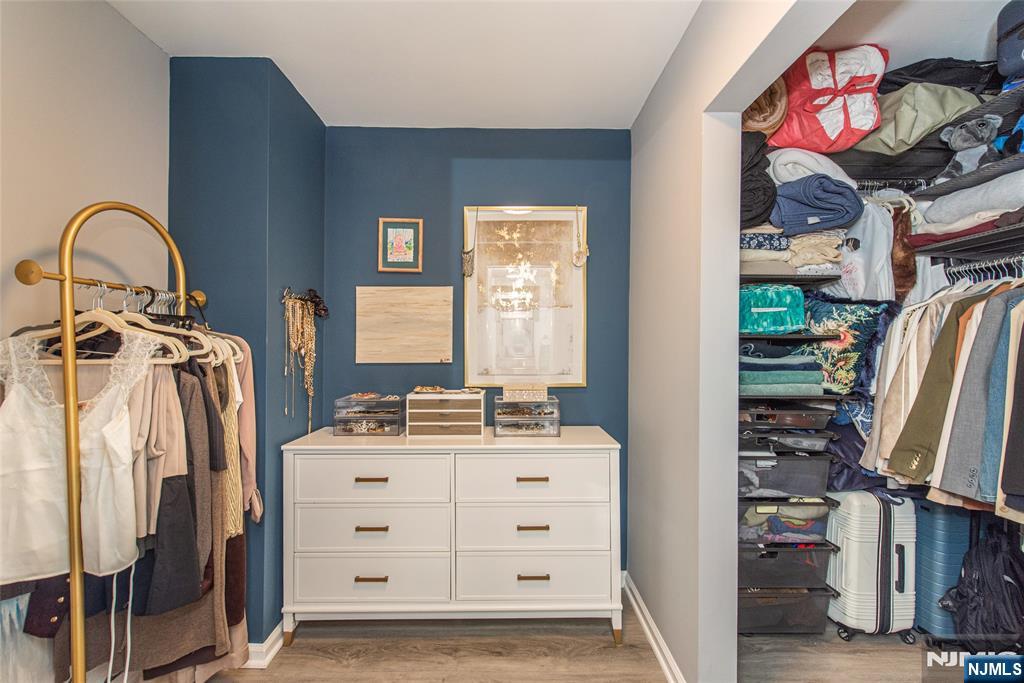 300 Main Street, Unit 211 Little Falls, NJ 07424 - Photo 20 of 30 a view of walk in closet with clothes and shoes
