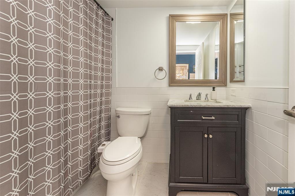 300 Main Street, Unit 211 Little Falls, NJ 07424 - Photo 21 of 30 a bathroom with a sink a toilet and a mirror