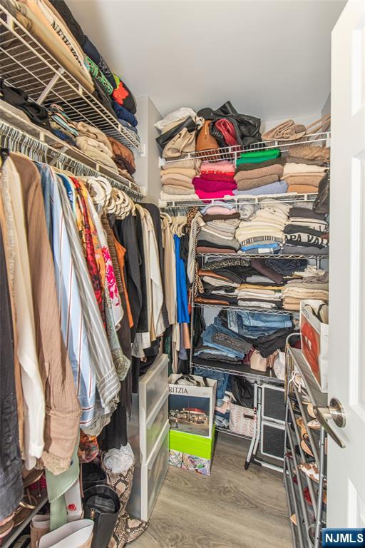 300 Main Street, Unit 211 Little Falls, NJ 07424 - Photo 24 of 30 a view of walk in closet with clothes and shoes