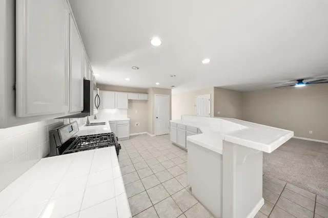 a kitchen with stainless steel appliances a sink stove and cabinets