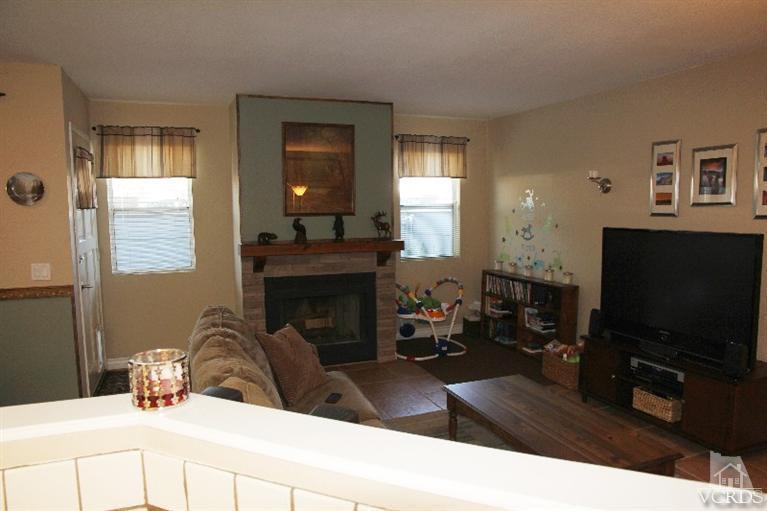 3970 Cochran Street, Unit 83 Simi Valley, CA 93063 - Photo 3 of 12 a living room with furniture a flat screen tv and a fireplace