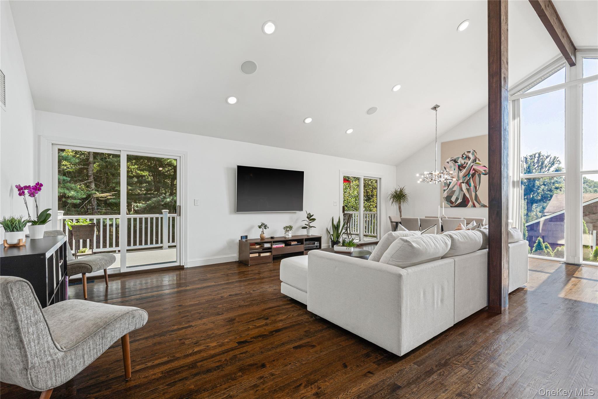a living room with furniture a large window and a flat screen tv