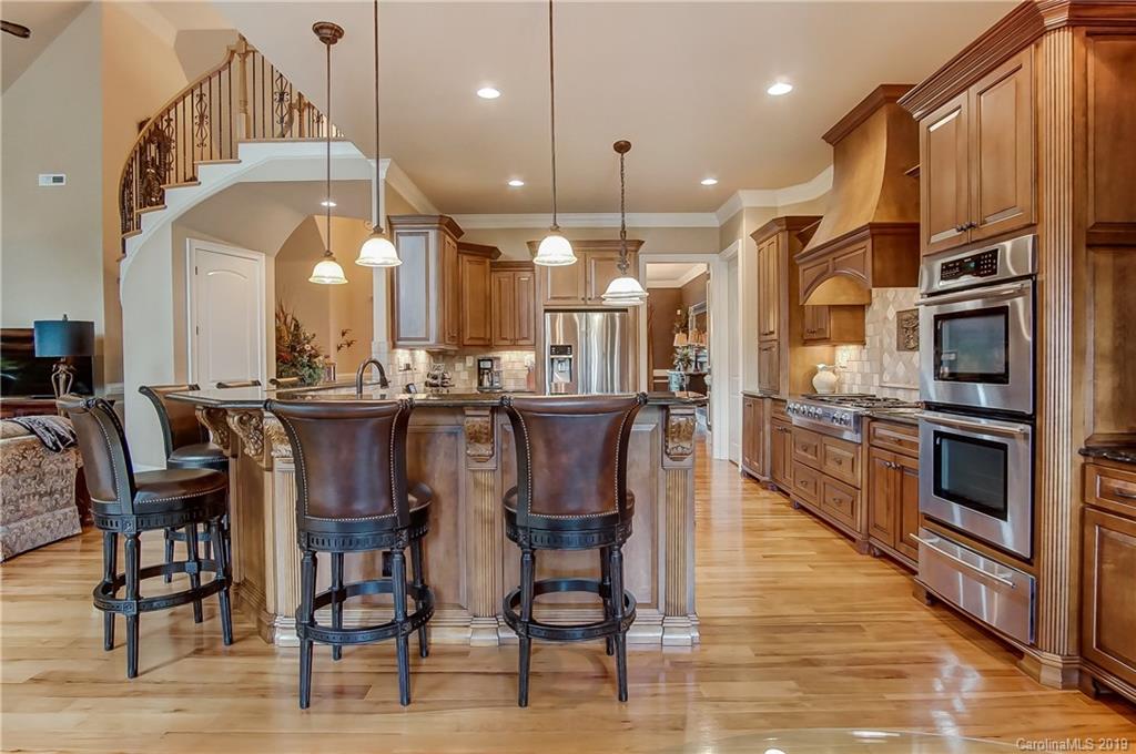 556 Medora Lane Fort Mill, SC 29708 - Photo 11 of 47 a kitchen with stainless steel appliances kitchen island granite countertop a table chairs and a refrigerator