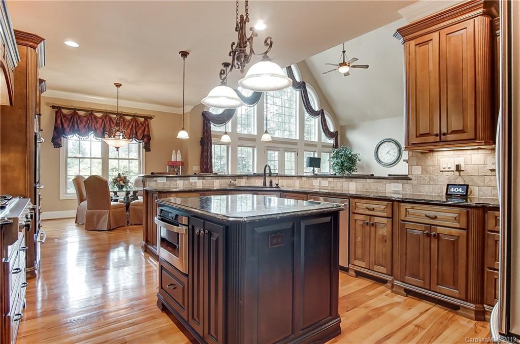 556 Medora Lane Fort Mill, SC 29708 - Photo 13 of 47 a kitchen with stainless steel appliances granite countertop a sink a stove and a wooden floors