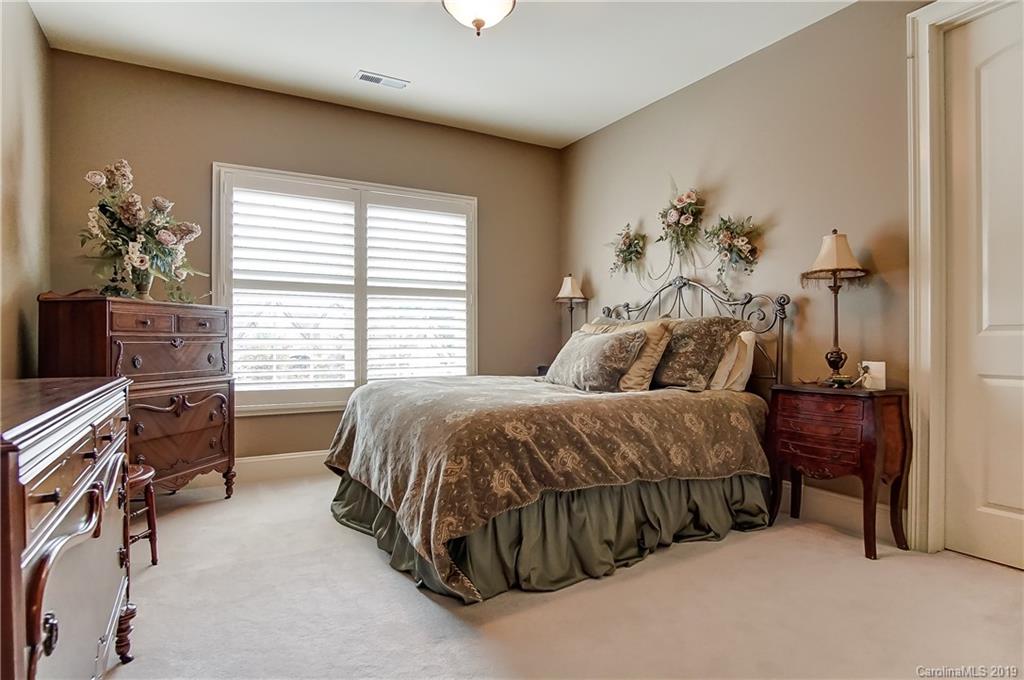 556 Medora Lane Fort Mill, SC 29708 - Photo 19 of 47 a bedroom with a bed and a chandelier