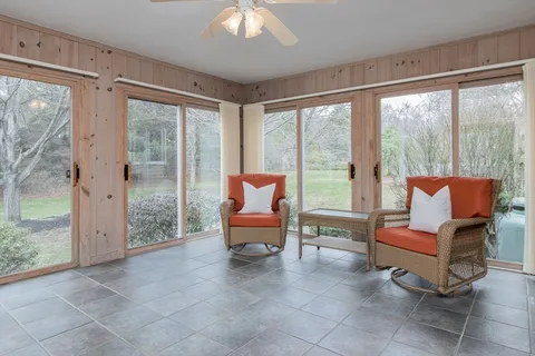 a living room with furniture and a floor to ceiling window