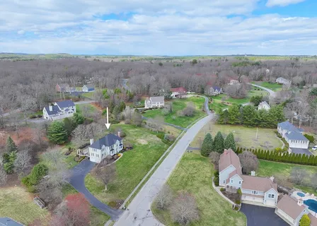an aerial view of a house with a garden and lake view