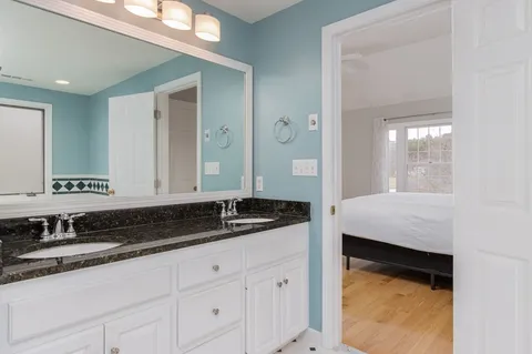 a bathroom with a granite countertop sink and a mirror