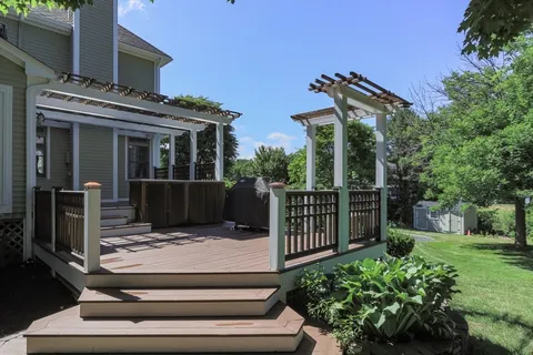 a view of a house with a small yard plants and large tree