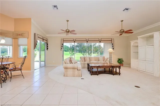 a living room with furniture and large windows