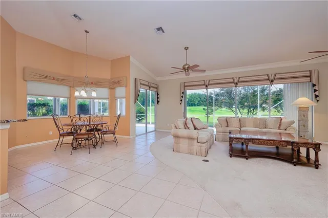 a dining room with furniture and a large window