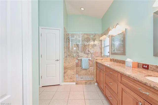 a large bathroom with a granite countertop sink a mirror and a bathtub