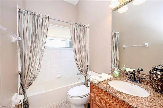 a bathroom with a granite countertop sink toilet a mirror and shower