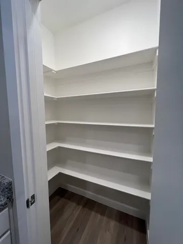 a view of walk in closet with empty racks
