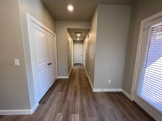 a view of a hallway with wooden floor and staircase