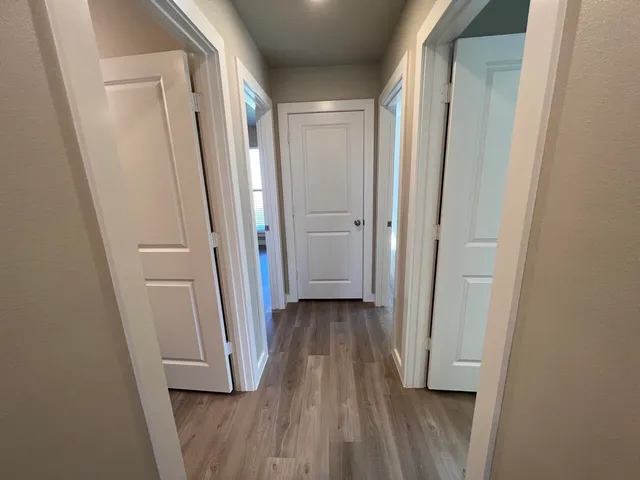 a view of a hallway with wooden floor and closet