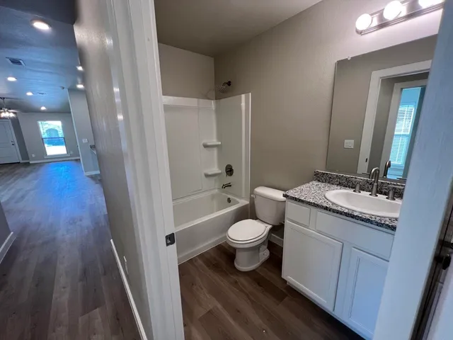a bathroom with a granite countertop sink toilet and shower